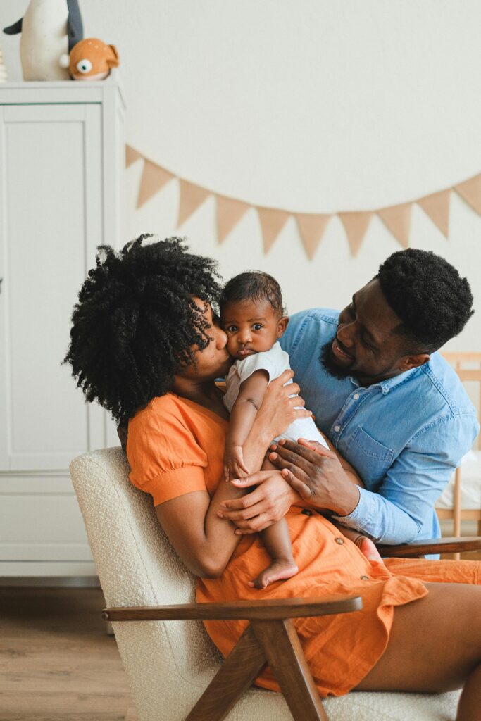 A heartwarming moment of parents embracing their baby in a cozy setting.